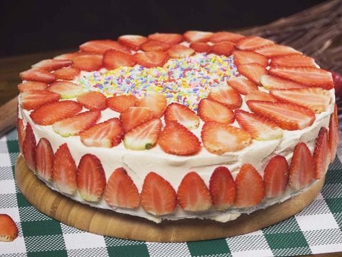 Strawberry Cream Cake Recipe, A soft sponge cake brushed with red wine, with buttercream frosting, then topped with sliced fresh strawberries..