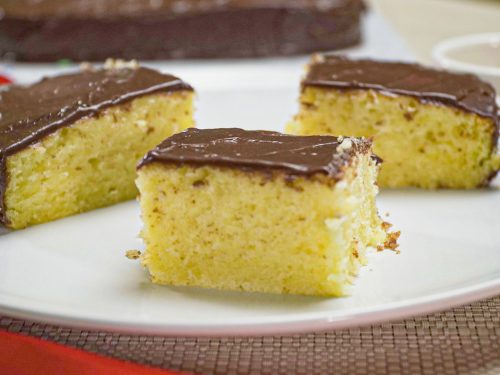 Buttery Vanilla Cake Recipe, Vanilla cake topped with chocolate frosting served on white plates