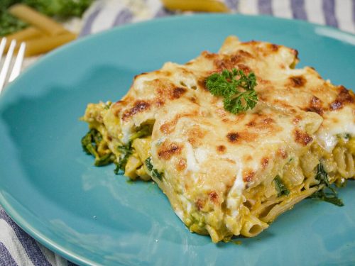 Baked Pumpkin Pasta Recipe, Penne pasta with pumpkin sauce, topped with three types of melted cheese and parsley on a blue plate