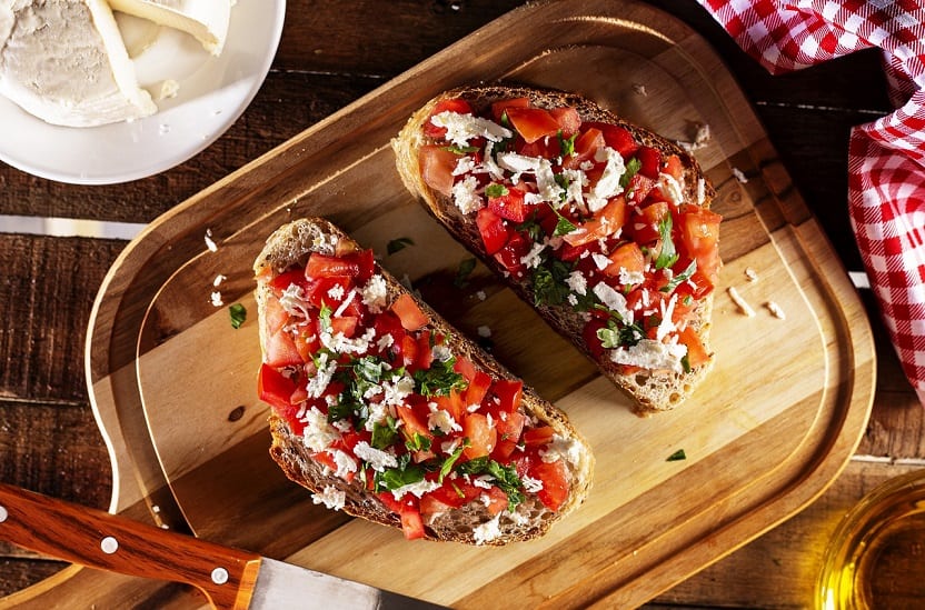 a top view bruschetta on a wooden chopping board