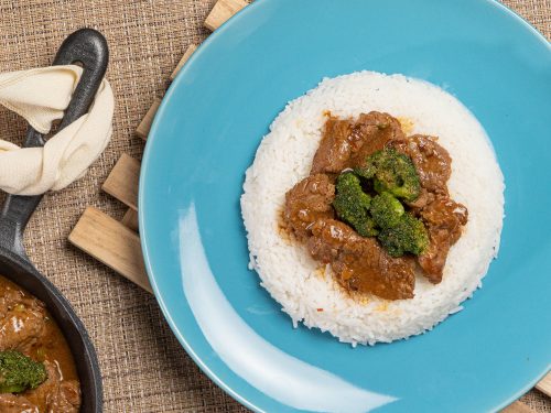 Broccoli Beef Stir Fry Recipe, Broccoli beef stir fry served on a bed of rice over a blue plate