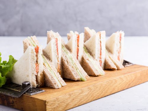 English tea sandwiches platter on wooden board