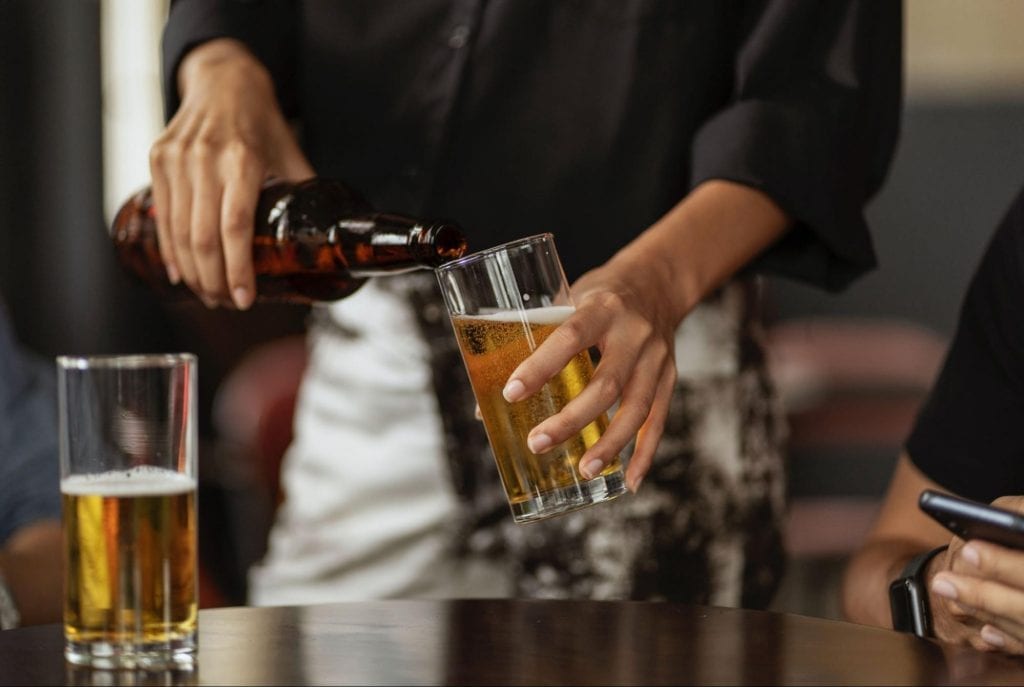 Person pouring beer into a glass