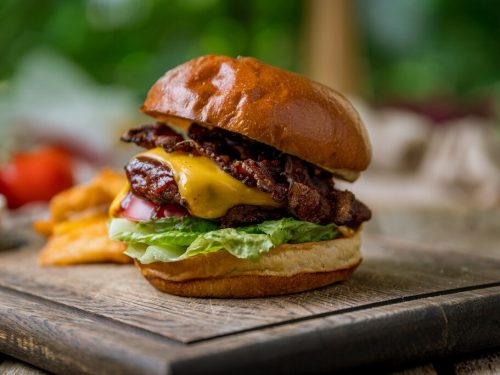 travis scott burger with meat, cheese and bacon on the board