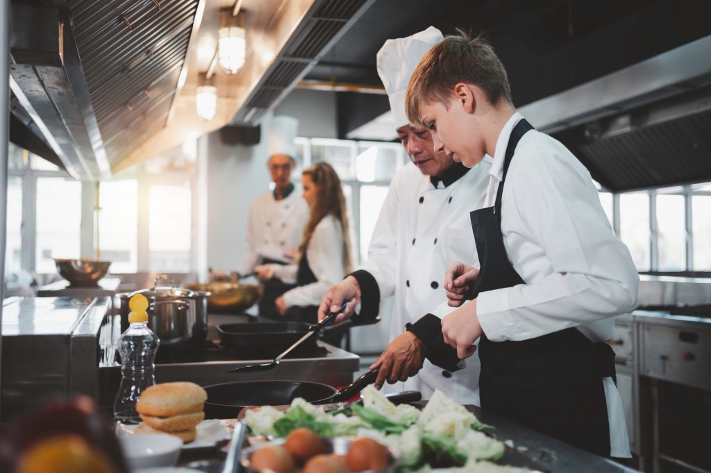 Chef teaching students to cook in the kitchen at a cooking school